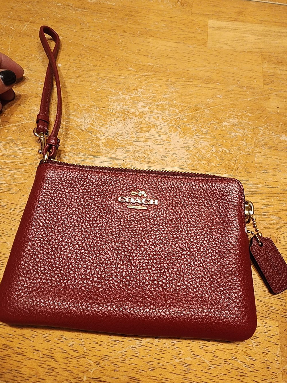 red polished pebble leather Coach wristlet, featuring gold-tone hardware